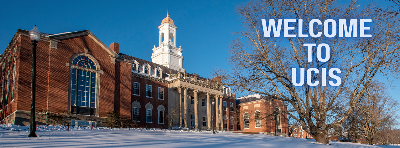 [ID: The Wilbur Cross building sits atop a snow covered hill: a dark red brick building with cement pillars and many windows. Atop the building sits a white cupola with a gold dome. The words "Welcome to UCIS" are displayed across the baren oak tree that sits to the right of the building.]